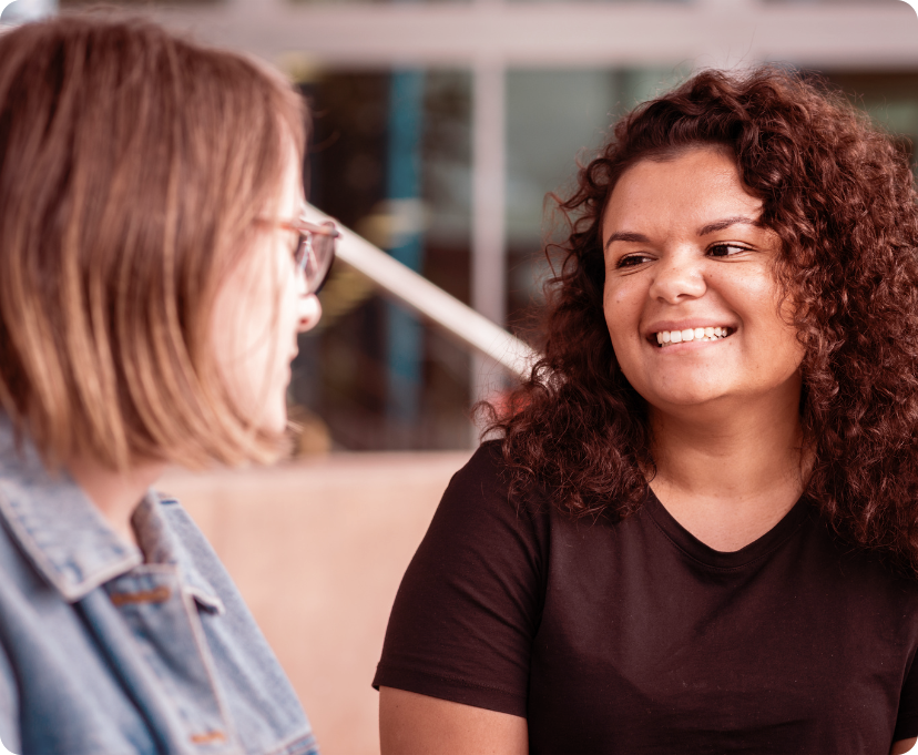 Two women having a conversation and smiling at each other